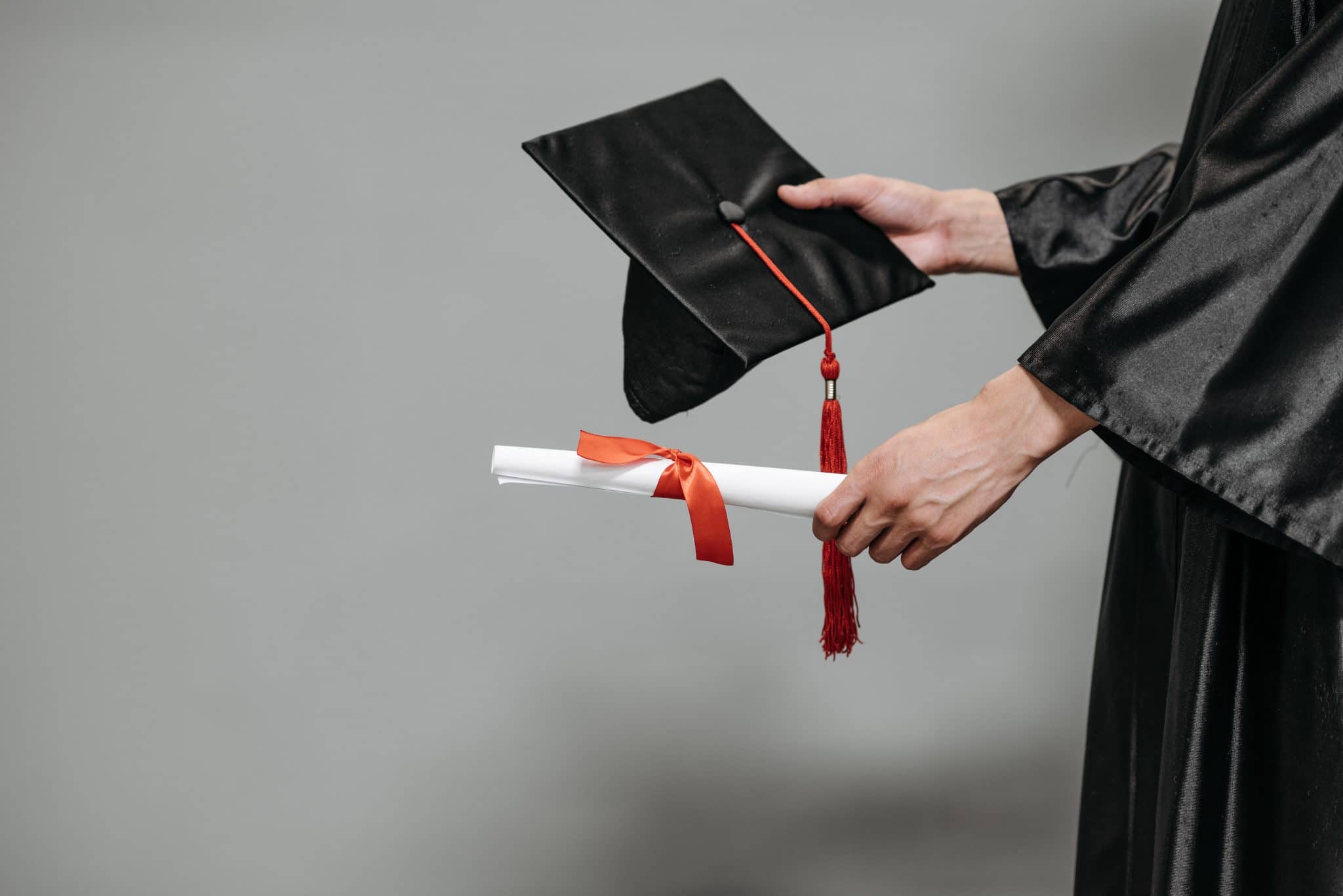 A graduate holding accountant degree certificate and mortarboard hat
