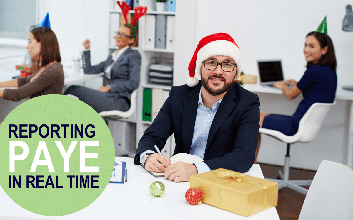 A man sits in an office wearing a santa hat